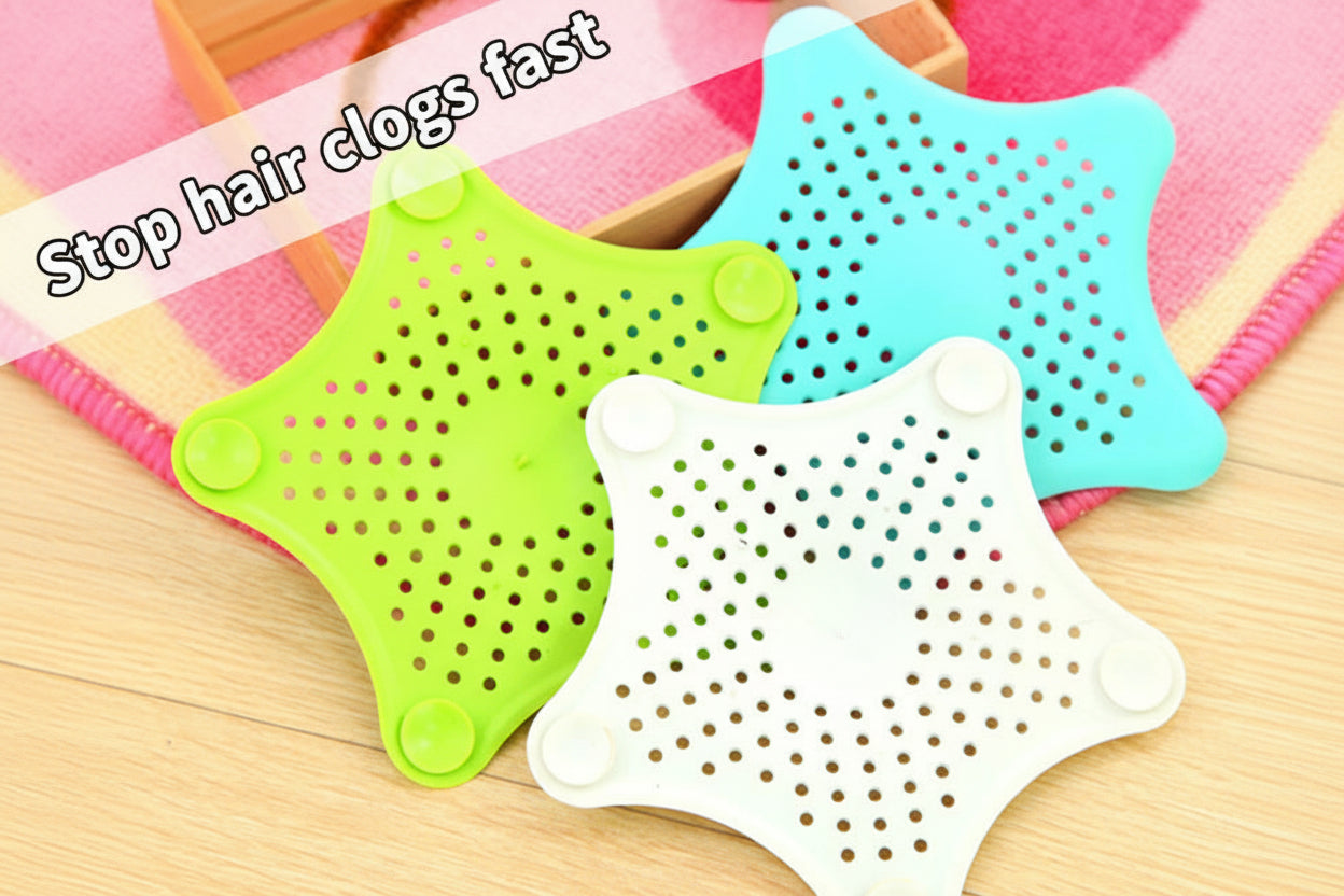 Three star-shaped silicone bath drain covers in green, white, and blue on a wooden surface.